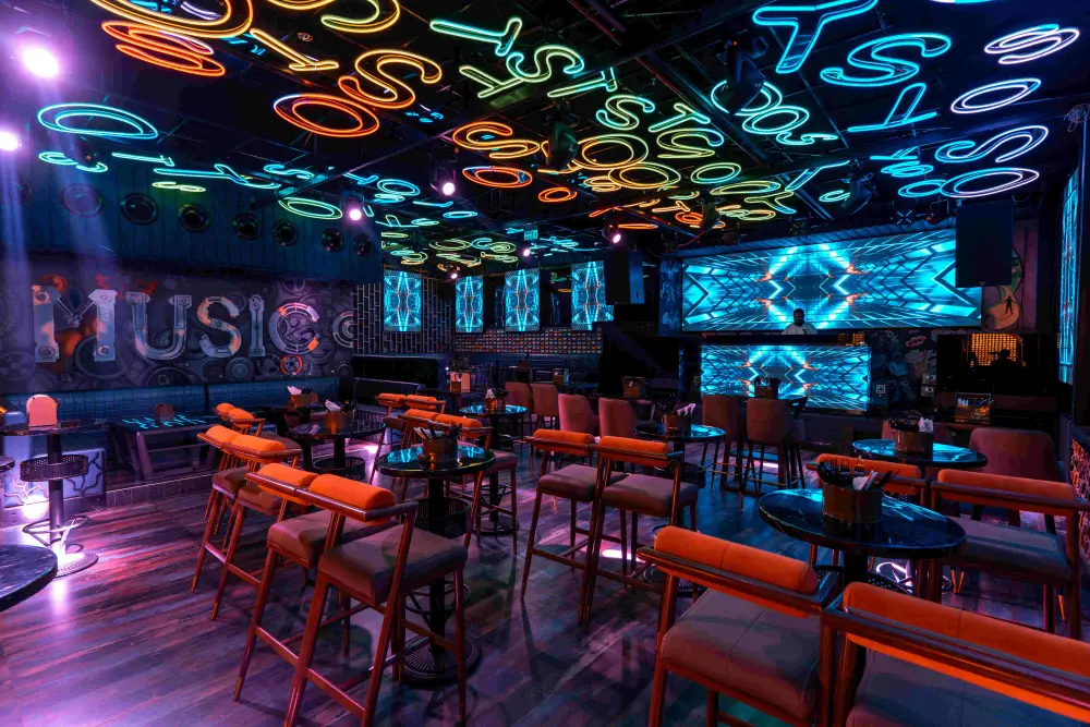 Crowd dancing under neon lighting on the main floor at TOS Club Hyderabad